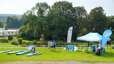 Blue paddleboards laid out on the grass