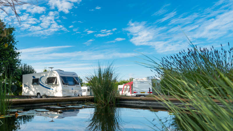 Caravans at Bath Chew Valley Caravan Park in Somerset basking in the blue sky.