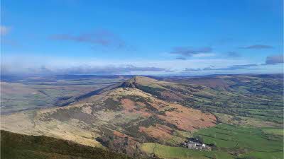 A view from Mam Tor with miles of rolling hills under a blue sky