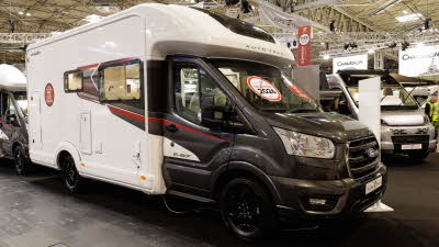 The Auto-Trail F-Line F67 has a black cab and white coachbuilt body with black and red striped decals.  