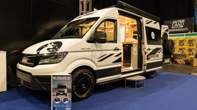 The Landseer Artemis is cream with black striking decals.  Its sliding door is open and there is a metal step to gain easy access.