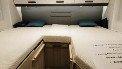 The Sun Living C Series 70 DL has a two fixed single beds at the rear.  There are two cushions on each bed.  Over head there are three lockers in cream with black handles.