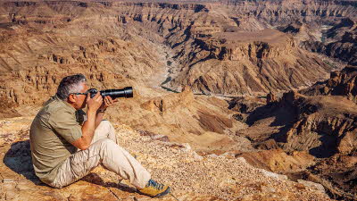 Shutterstock photo of man taking photographs at Fish River Canyon