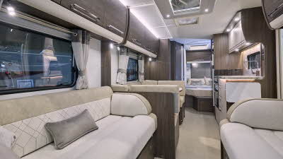 Buccaneer Aruba’s interior has cream and beige upholstery with dark wooden furniture.  There is a fixed island bed in the bedroom at the rear.  There is a dinette opposite the kitchen in the middle.