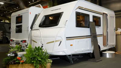 Weinsberg CaraOne 390 QD's exterior is white with brown and gold graphics.  The door is open and there is a step to enable easy access to the interior.