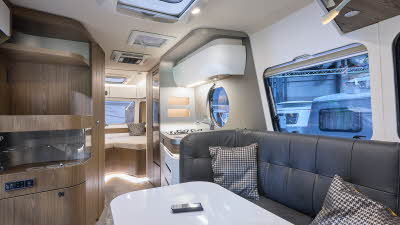 Eriba Touring 820 interior, black upholstery, white table, wooden units, fixed bed, three skylights