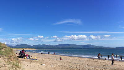 Sandy beach with blue skies and mountains in the distance