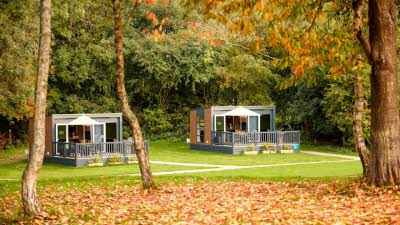 Two glamping pods surrounded by Autumn leaves