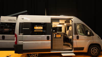 The VANTourer 540 D is sliver with black and gold decals.  Its sliding door and retractable step are open.