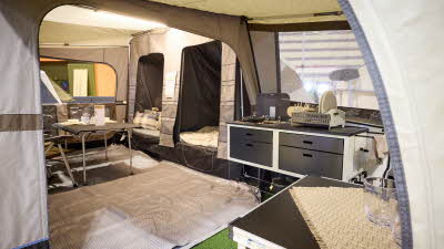 The Camp-Let Earth’s kitchen has two units, there is a ground sheet and the two bedroom doors are open, there is a dining table and chairs in the main tent.