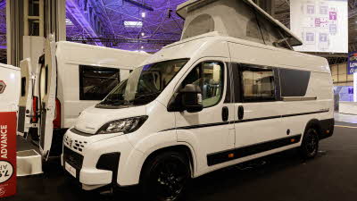 The Auto-Trail Expedition 68 is white with black trim.  Its rising roof is open.