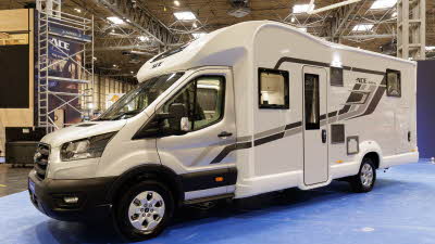 The Ace Motorhomes 1500 SL has a silver cab with a white coachbuilt body.  It has pale and dark grey decals.  