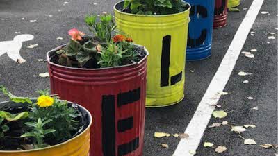 Colourful metal rubbish bins repurposed as flower pots 