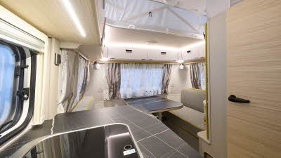 Eriba Touring 560 interior, shiny hob, grey/yellow upholstery, wood furniture, pop top roof