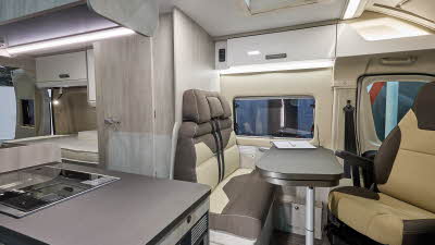 Roller Team Livingstone 6’s interior has brown and beige upholstery.  Its furniture is wooden.  At the rear there is a fixed bed.  The two rear seats have seatbelts.  The table is folded and can be extended.