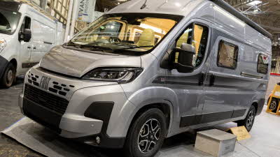 The Vantage TEO is silver, its sliding door is closed.  There is a step to gain easy access.