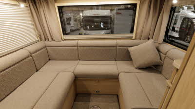 The Auto-Trail Expedition C72 has brown upholstery and has a u shaped sofa in its rear lounge.  This has three large windows with blinds and curtains.