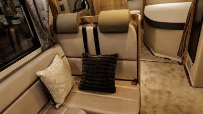 The Bailey Autograph 79-4F has beige and brown upholstery.  The rest of the interior matches these shades.  There is a fixed bed, on the floors there is removable beige carpet.  The washroom is at the rear.