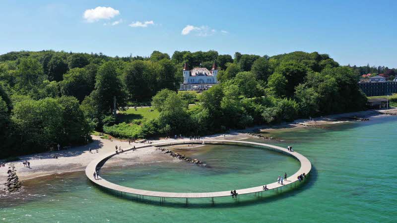 An infinity bridge from the sandy beach over the water in Aarhus Denmark
