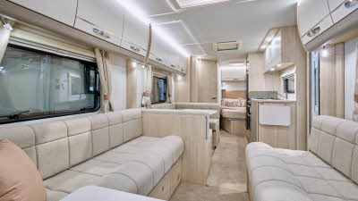 Elddis Avanté 840’s interior has cream upholstery with pale wooden furniture.  The kitchen is in the middle and there’s a dinette opposite.  There is a fixed island bed to the rear