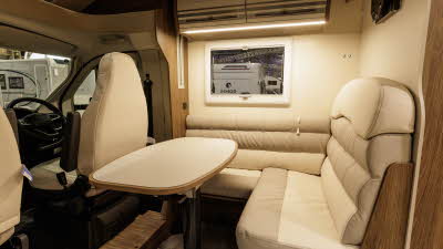 The Roller Team T-Line 700 has cream/beige upholstery with matching cabinets.  There is a matching table in front of the sofas.  