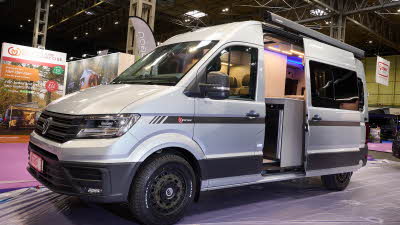 The Benimar Tessoro T861 has a silver cab with a white body.  There is a black step by the open habitation door. 