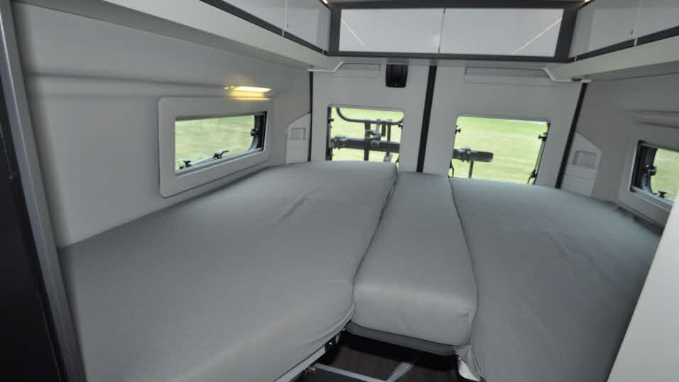 large campervan bed with two separate mattresses and connecting centre