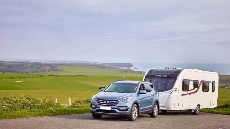 Car towing a caravan on a road