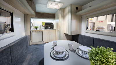 Campmaster King interior, blue upholstery, light wood furniture, rear kitchen, skylight