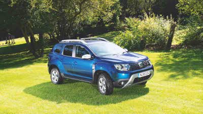 Blue Dacia Duster parked on grass