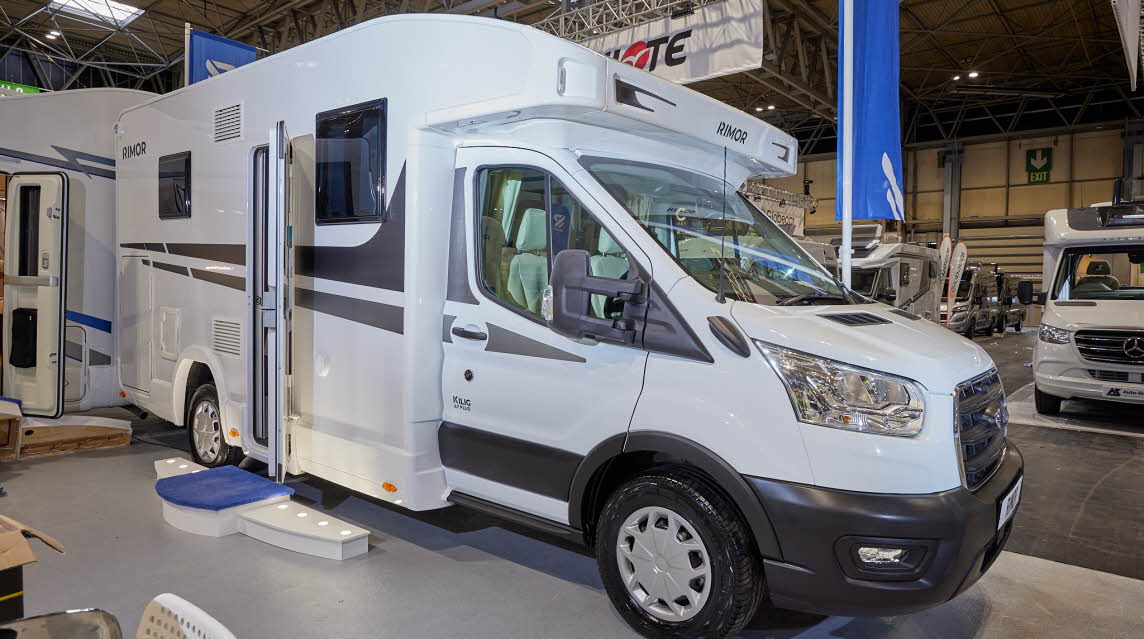 Rimor Kilig 67 Plus has a predominately white exterior with grey graphics. The habitation door is open with a step to gain easy access. 