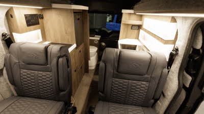 The Hillside Leisure Cromford has dark brown upholstery with wooden cabinets.  To the rear there is a fixed toilet.