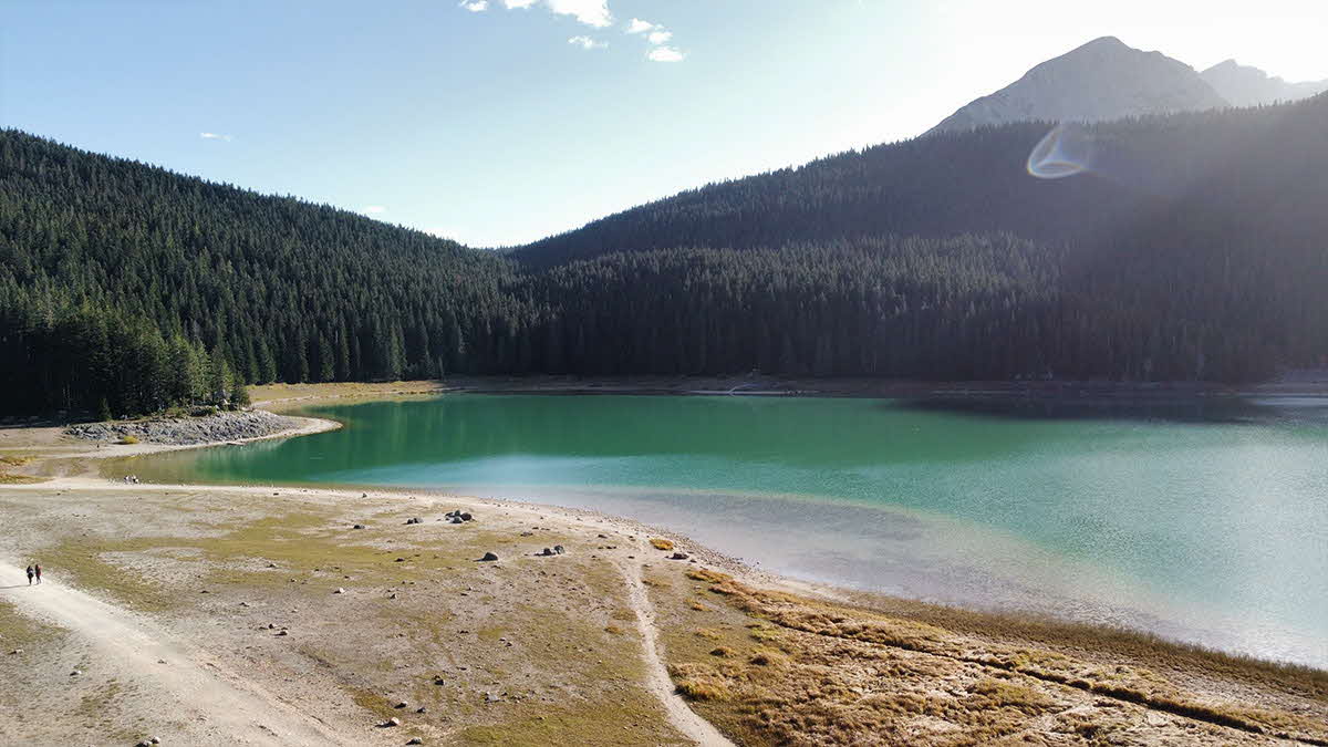 Marcus Leech and family walking by a lake set within the Montenegro mountains