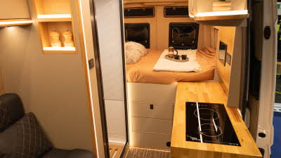 The Landseer Artemis has black upholstery and has a solid wood kitchen worktop.  There is a fixed rear bed with a tray with a cafetière and two cups