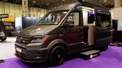 The Bespoke Leisure Bespoke Edition Volkswagen Crafter has metallic paint, its sliding door is open and there is a step in front of it to gain easy access.