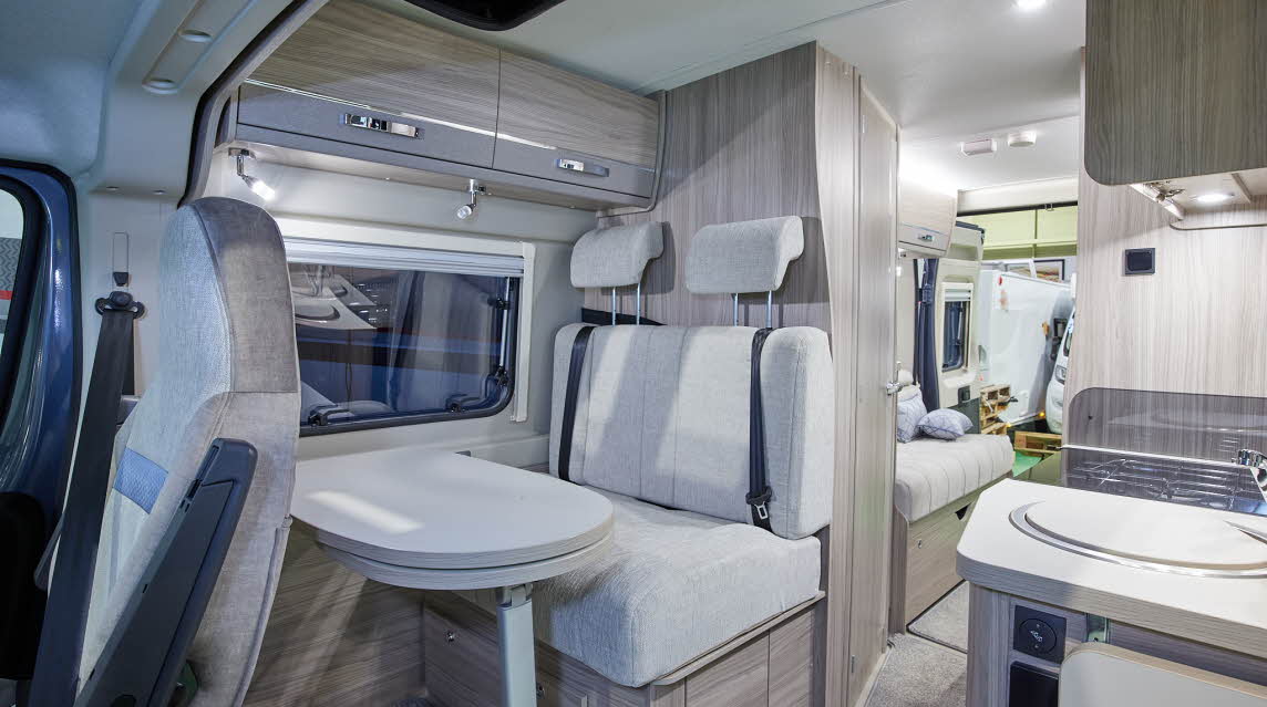 Van conversion interior, cream upholstery, wooden furniture