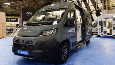 The Ace Motorhomes 1200 GL is dark grey.  Its sliding door and skylight are open.  Its number plate is blue.