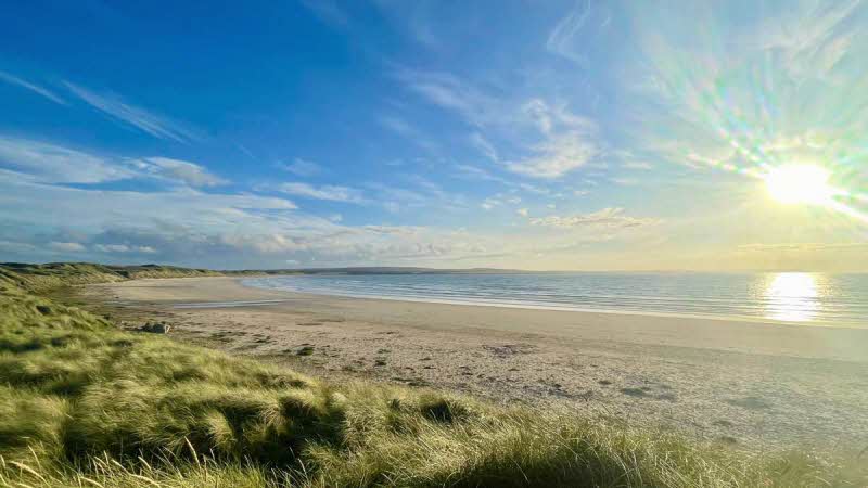 Sun, sea and sand at Dunnet Bay with the sand dunes under a blue sky
