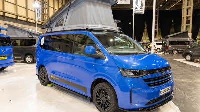 The Rolling Homes Camper Ltd Columbus S is blue.  Its rising roof is fully extended.