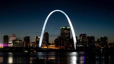 The city of St Louis in the night sky with the Gateway Arch towering over lighting up in the night sky
