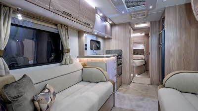 Elddis Crusader Tempest's interior has pale wood furniture and its upholstery is gold and cream with black piping.  The bedroom is to the rear and it has a large skylight.