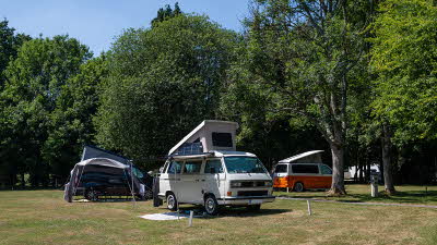 Three campervans on electric grass pitches as Alderstead Heath Club Campsite