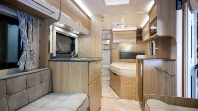 Bailey Phoenix+ 440 interior, grey upholstery, light wood/cream overhead lockers, lounge, fixed bed, washroom, two skylights