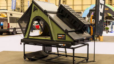 The TentBox Cargo 2.0 has a green canvas and a grey roof.  There is a storage box clipped to the hard shell roof.