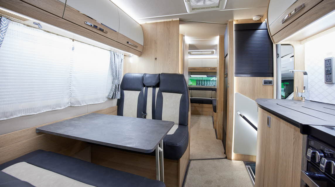 Coachbuilt interior, grey and cream upholstery, wood and cream furniture