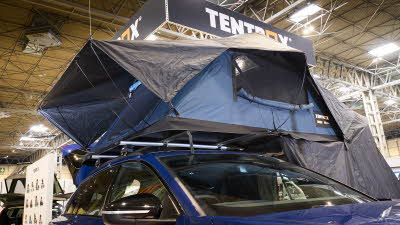 TentBox Lite XL has blue and black canvas.  It has an extension.  It is shown on a blue Audi. 