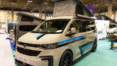 The Knights Prestige Tourer has a cream exterior with black and blue decals.  Its rising roof is open.