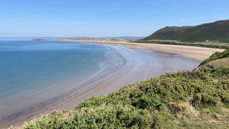 a sweeping sandy beach with crytal clear shallows stretching to the horizon