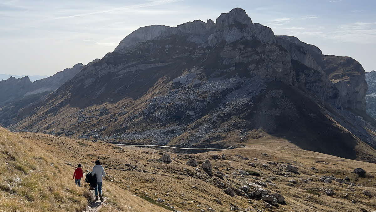 Marcus Leech and family walking beside a large mountain in Montenegro 