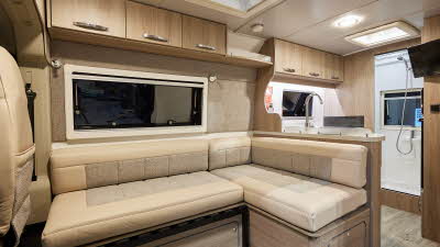 Moto-Trek Ltd Leisure-Treka EB Elite has leather and material two tone upholstery.  There are wooden overhead lockers. The floor is wooden laminate.  Towards the rear of the vehicle there is a end washroom.